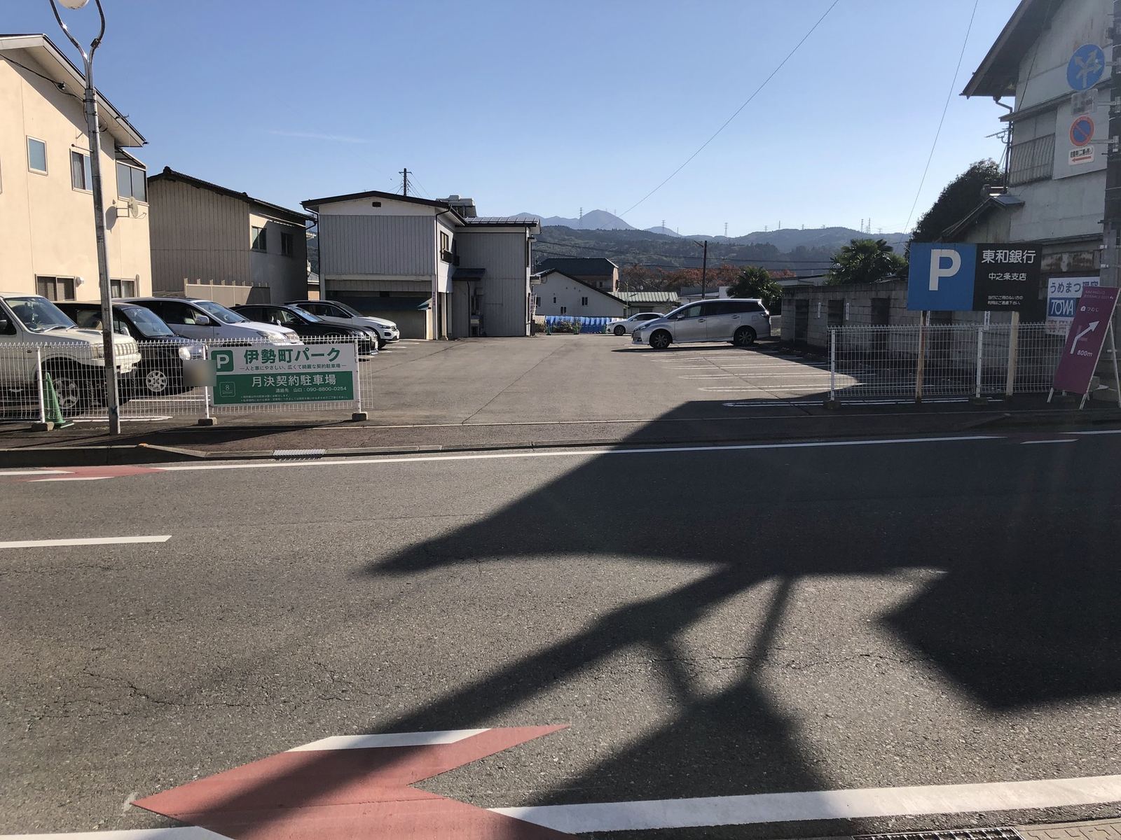 道路から見た進入口。左に「伊勢町パーク」の看板、右隣に東和銀行中之条支店の駐車場の看板。